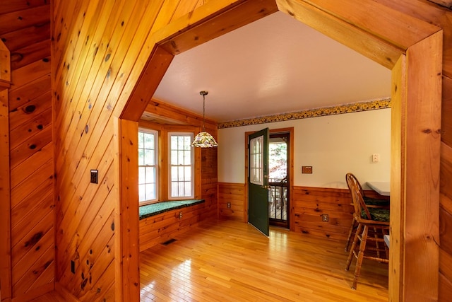 dining room with light hardwood / wood-style floors and wooden walls