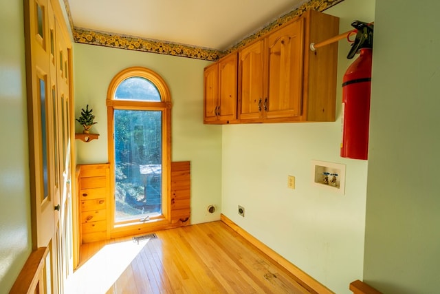 laundry room with hookup for an electric dryer, light hardwood / wood-style floors, cabinets, and hookup for a washing machine