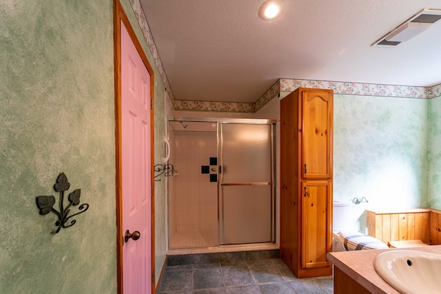 bathroom with vanity, a textured ceiling, and a shower with shower door