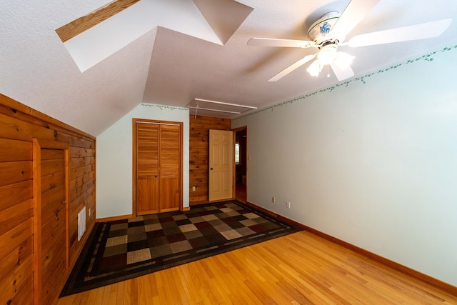 interior space featuring hardwood / wood-style floors, ceiling fan, lofted ceiling, and a textured ceiling