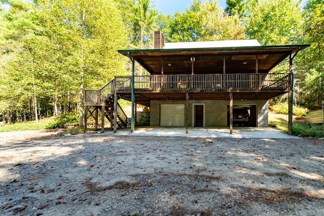 rear view of house featuring a garage and a deck