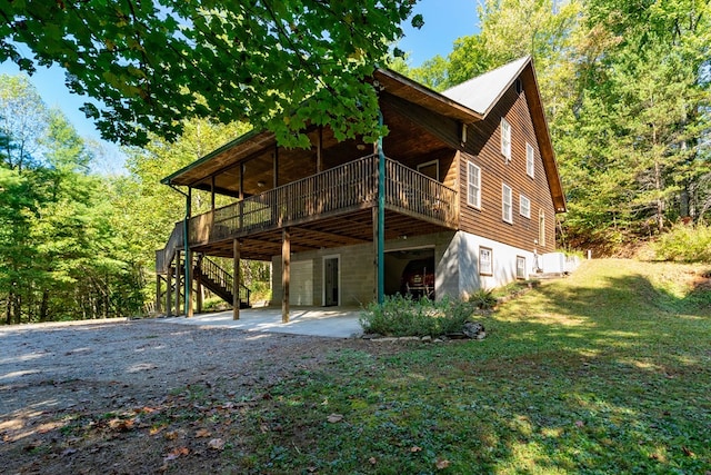 rear view of property featuring a deck, a yard, and a patio