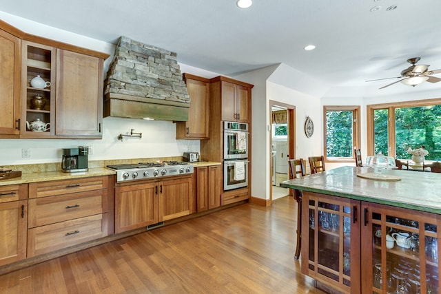 kitchen with hardwood / wood-style floors, beverage cooler, ceiling fan, premium range hood, and stainless steel appliances