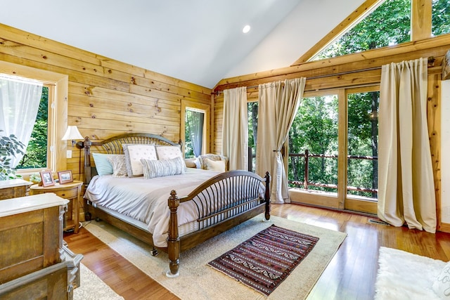 bedroom with access to exterior, light hardwood / wood-style flooring, multiple windows, and high vaulted ceiling