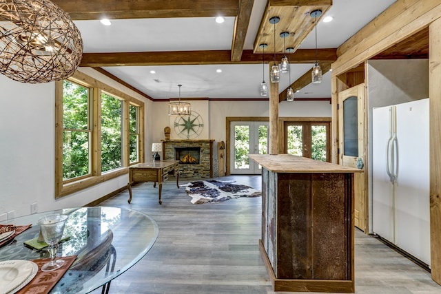 kitchen with french doors, light wood-type flooring, beam ceiling, and white refrigerator