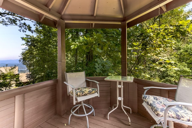 deck at dusk featuring a gazebo