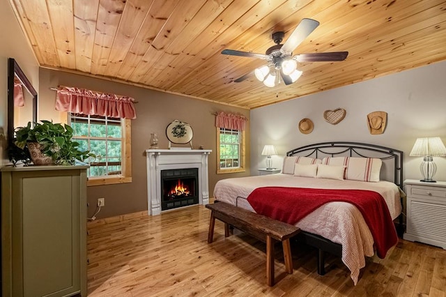 bedroom featuring ceiling fan, light hardwood / wood-style floors, multiple windows, and wood ceiling