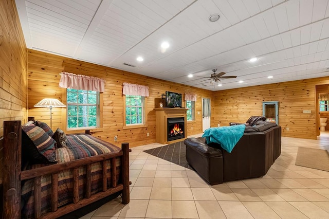 tiled living room with ceiling fan and wood walls