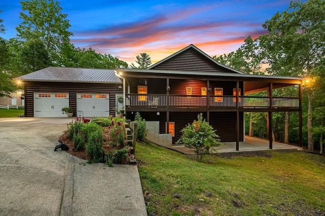 exterior space featuring a lawn, a wooden deck, and a garage