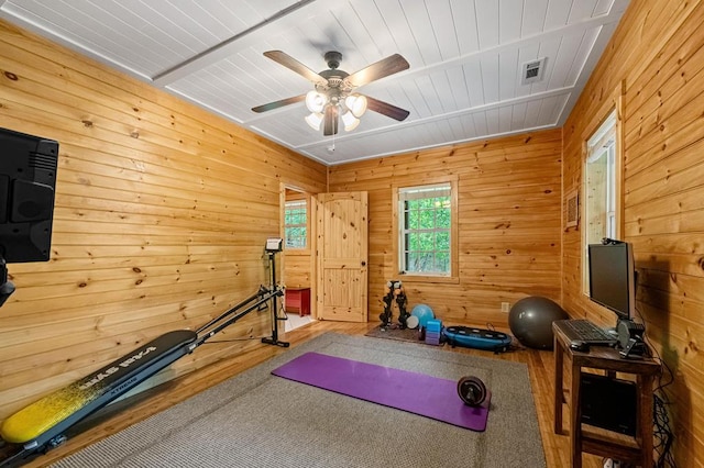 workout room with hardwood / wood-style floors, ceiling fan, wood walls, and wooden ceiling