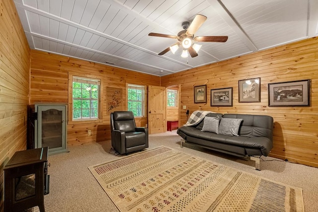 carpeted living room featuring ceiling fan, wood walls, and wood ceiling