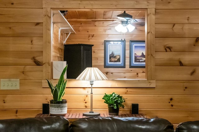 interior space with ceiling fan and wooden walls