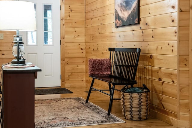 living area with wood-type flooring and wood walls