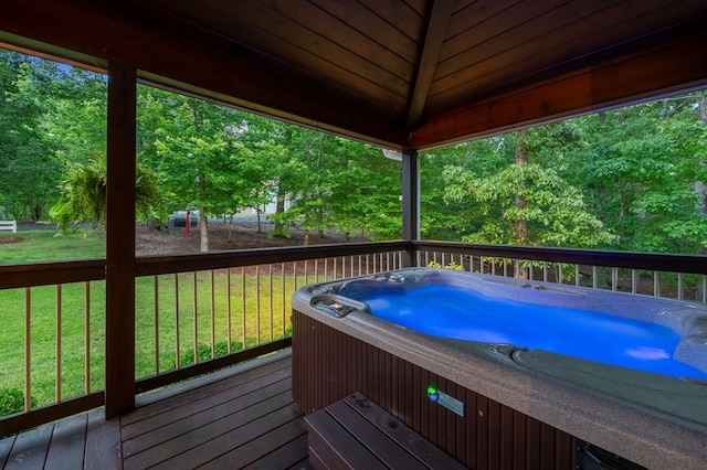 wooden terrace with a yard and a hot tub