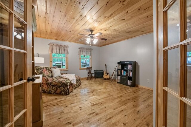 living area featuring ceiling fan, light hardwood / wood-style floors, wood ceiling, and french doors