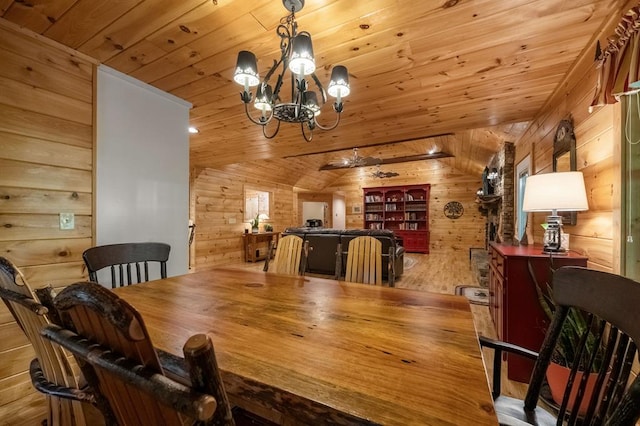 dining area with a notable chandelier, light hardwood / wood-style floors, lofted ceiling, and wooden walls