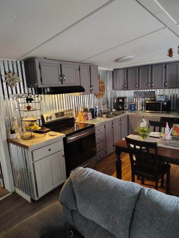 kitchen with a sink, stainless steel appliances, and gray cabinets