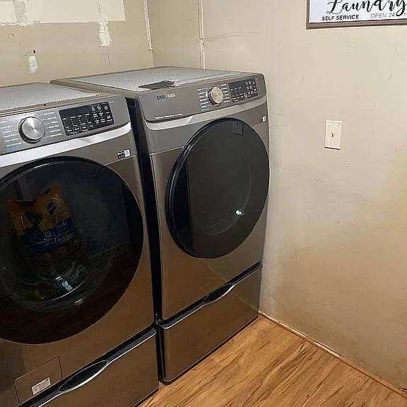 clothes washing area featuring washer and dryer and light wood-style floors