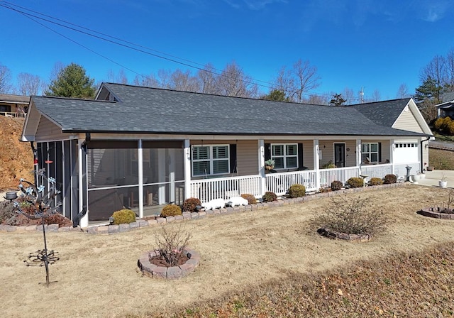 ranch-style home featuring a sunroom, covered porch, an attached garage, and roof with shingles