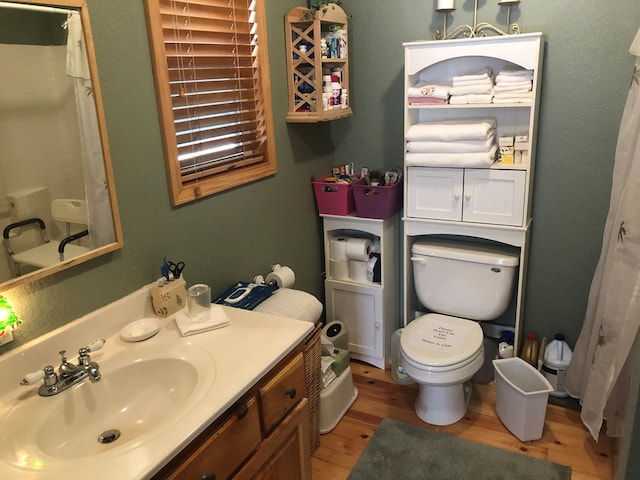 bathroom with a shower with shower curtain, vanity, wood-type flooring, and toilet