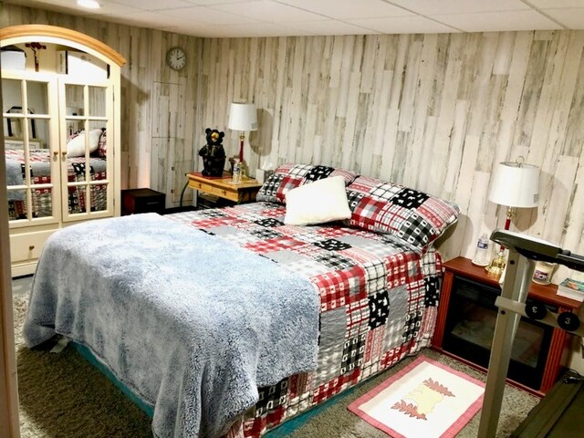 bedroom with carpet and wooden walls