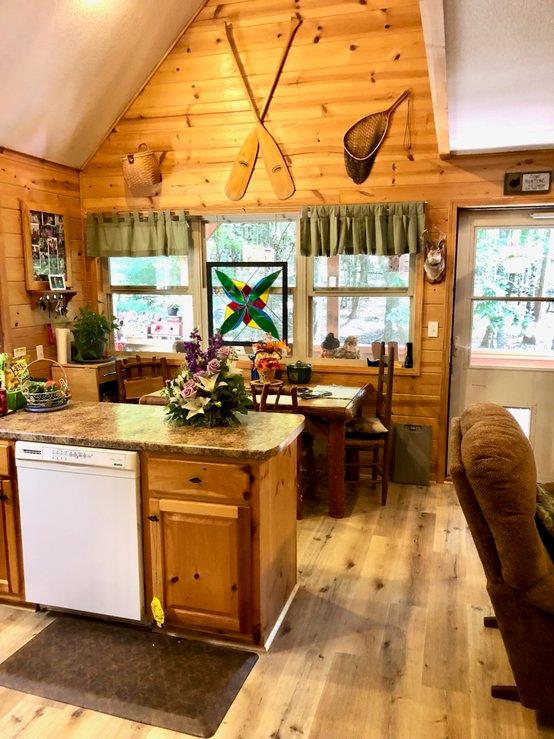 147 Blair Oaks Dr, Blairsville, GA 30512 - kitchen with dishwasher, wood walls, vaulted ceiling, light wood finished floors, and light stone countertops