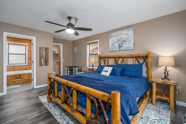 bedroom featuring baseboards, wood finished floors, ceiling fan, and ensuite bathroom