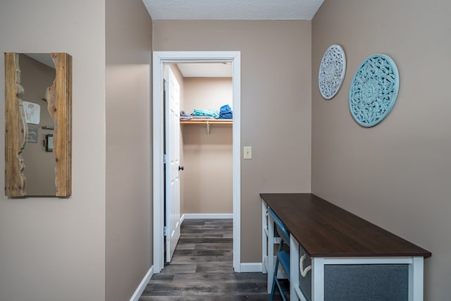 hall with dark wood-style flooring and baseboards