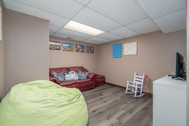 interior space featuring baseboards, visible vents, light wood-style floors, and a paneled ceiling