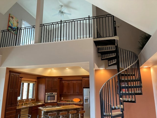 interior space with ceiling fan, sink, and a towering ceiling