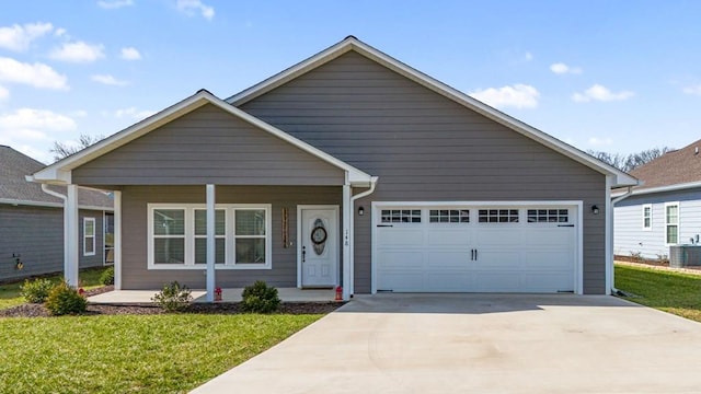 view of front of house with covered porch, a garage, a front yard, cooling unit, and driveway