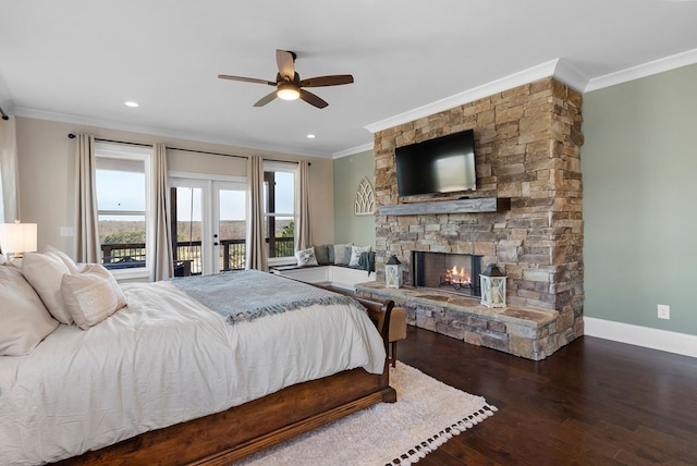 bedroom featuring crown molding, baseboards, a stone fireplace, wood finished floors, and access to outside