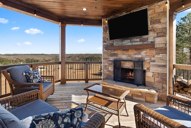 wooden terrace with an outdoor stone fireplace