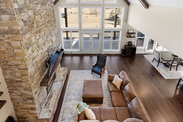 living room with beam ceiling, high vaulted ceiling, and wood finished floors