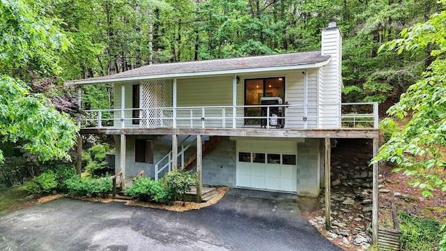 39 Briarwood Dr, Murphy, NC 28906 - view of front of house featuring an attached garage, a chimney, asphalt driveway, and a forest view