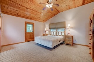 bedroom with vaulted ceiling, carpet, and wood ceiling