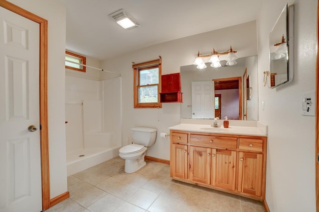 bathroom featuring vanity, tile patterned flooring, toilet, and a shower