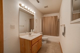 full bathroom featuring tile patterned flooring, vanity, shower / tub combo with curtain, and toilet