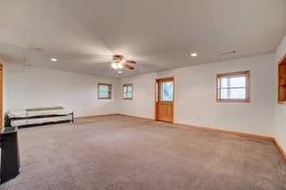 interior space with carpet and ceiling fan