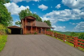 view of front facade with a carport and a balcony