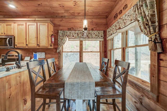 dining area with plenty of natural light, wooden walls, and wood ceiling