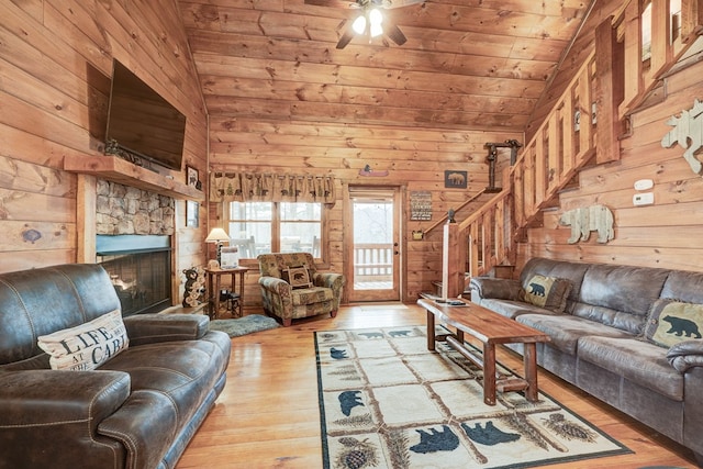 living area featuring wooden ceiling, wooden walls, wood finished floors, and vaulted ceiling