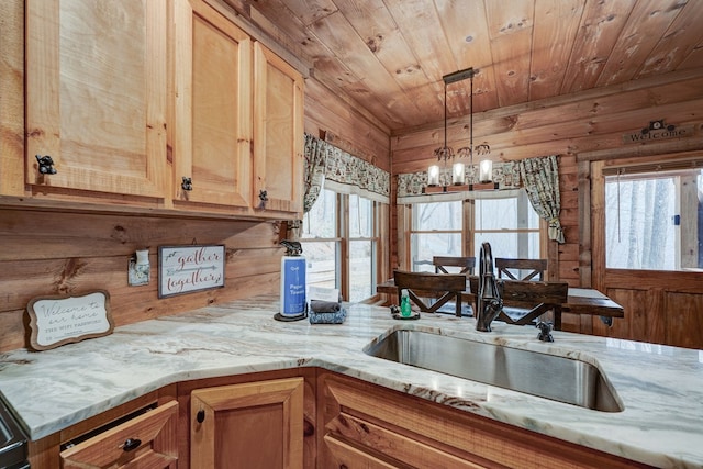 kitchen featuring a wealth of natural light, wooden walls, wooden ceiling, and a sink