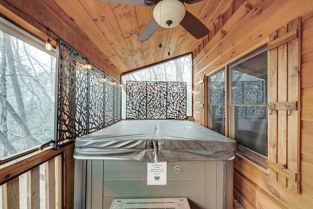 unfurnished sunroom with wooden ceiling and a ceiling fan