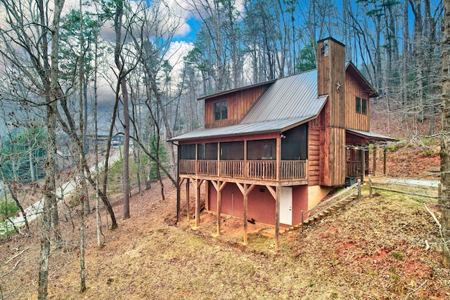 exterior space featuring a sunroom and a chimney