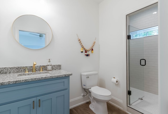 bathroom with vanity, hardwood / wood-style floors, a shower with door, and toilet