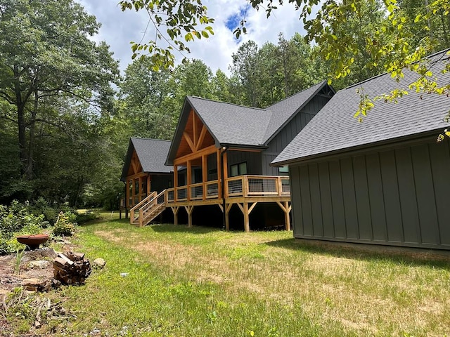 rear view of house with a deck and a lawn