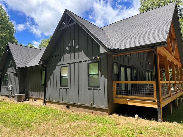 back of property with a yard and central air condition unit