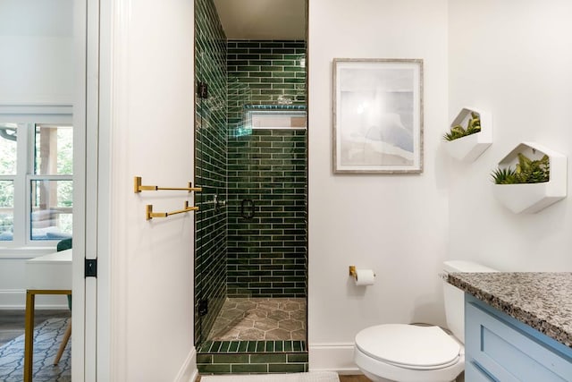 bathroom featuring vanity, toilet, and tiled shower