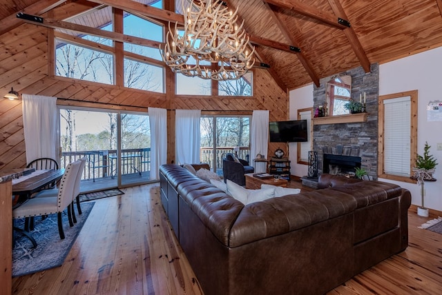 living room with wood ceiling, wood-type flooring, a fireplace, and beamed ceiling